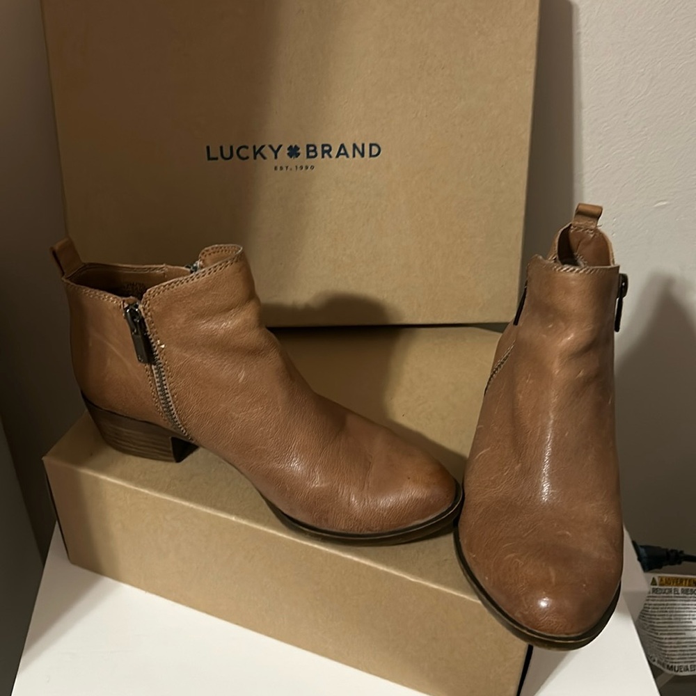 Women’s tan leather lucky brand ankle booties with 2 zippers on each side.